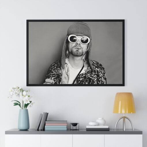 Black and white poster of Kurt Cobain wearing a winter hat and summer sunglasses, with a panther print jacket, embodying his unique style.