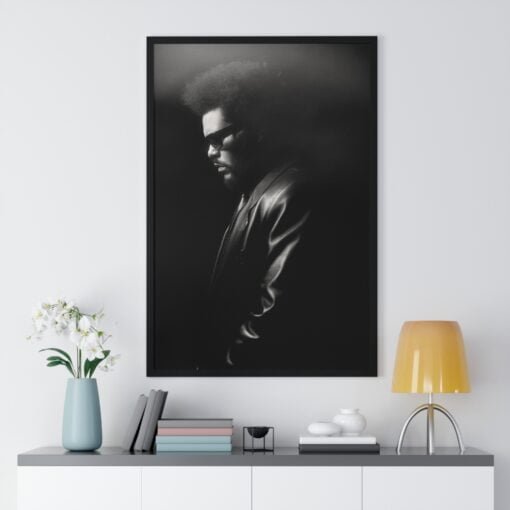 Artistic black and white framed poster of The Weeknd in profile, highlighting his facial features and afro under dramatic lighting, evoking a sense of mystery.