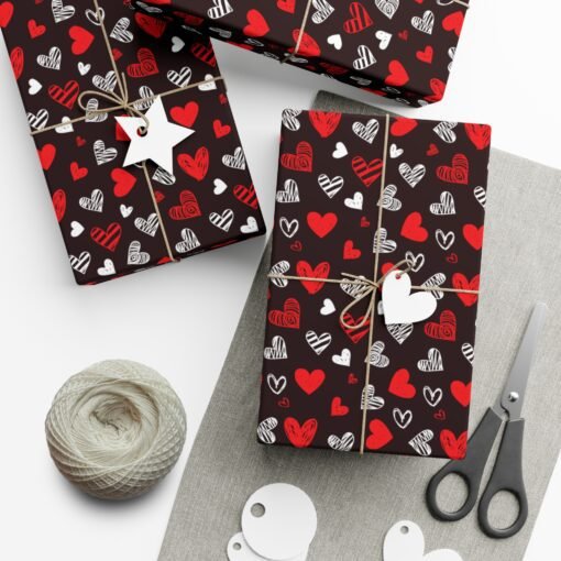 Elegant black gift wrap with red and white heart pattern, perfect for romantic occasions and Valentine's Day, available in satin and matte finishes.